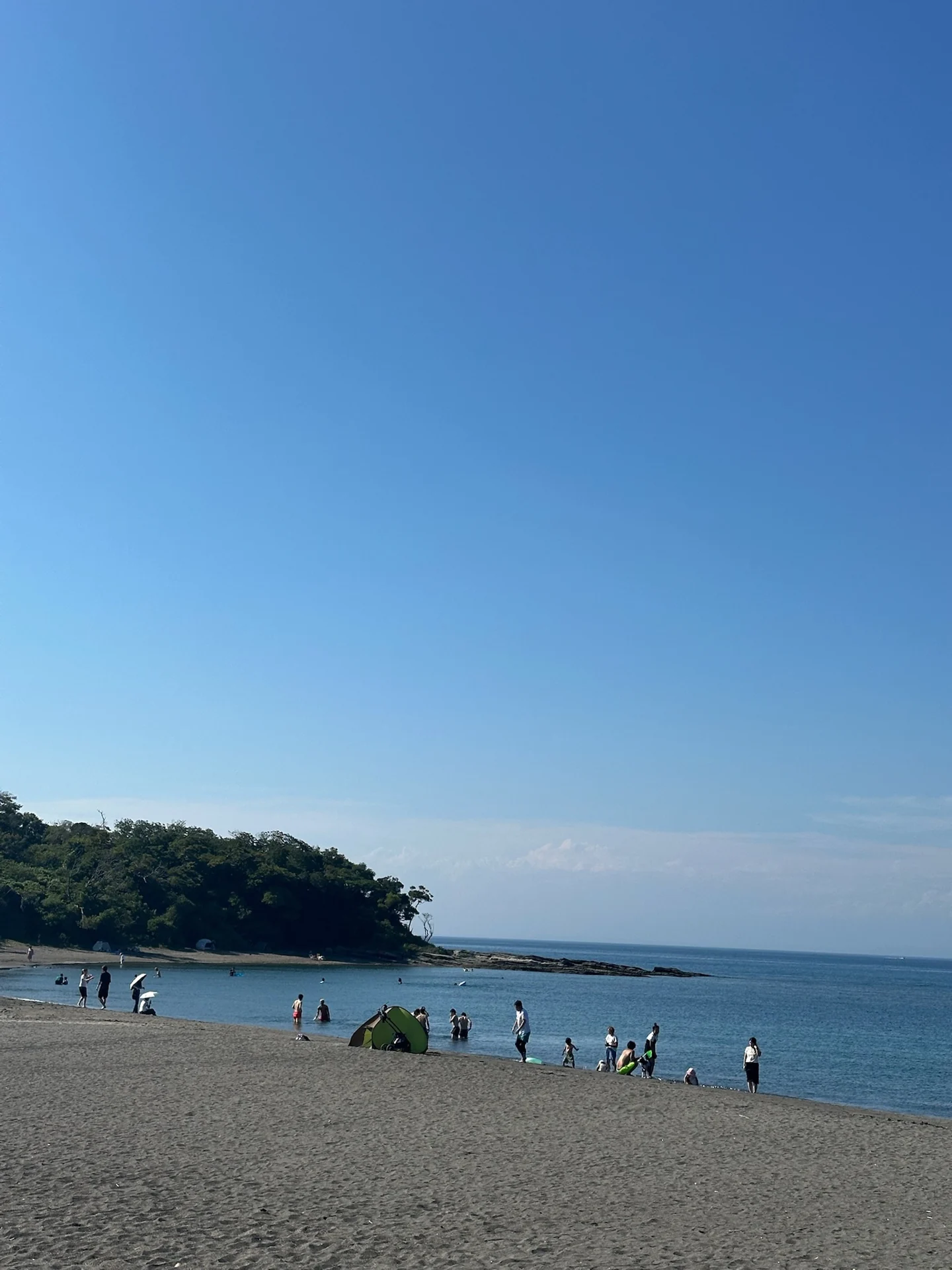 砂浜の向こうに緑の島が見える沖ノ島
